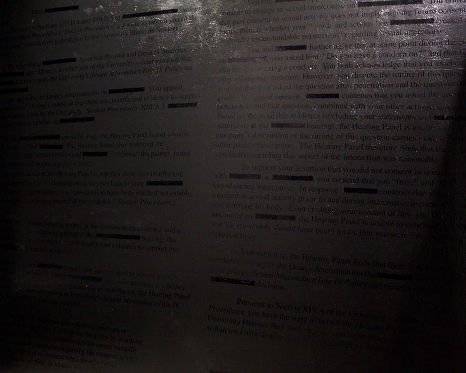 black vinyl transcript of sexual assault administrative letter on black wall